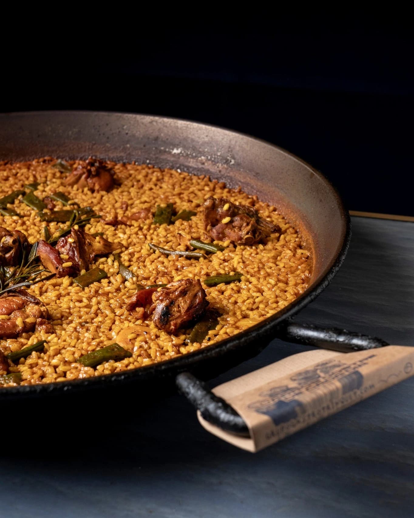 Paella cuisinée à la commande par Tavola, riz safrané, viande et romarin